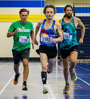 Men running in track event.