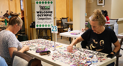Two women solving a jigsaw puzzle.