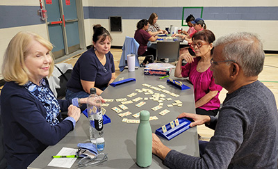 Four people playing rummikub.