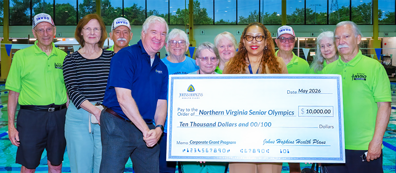 Men and women with Johns Hopkins Health Plans Corporate Grant Program check to NVSO in May 2026.